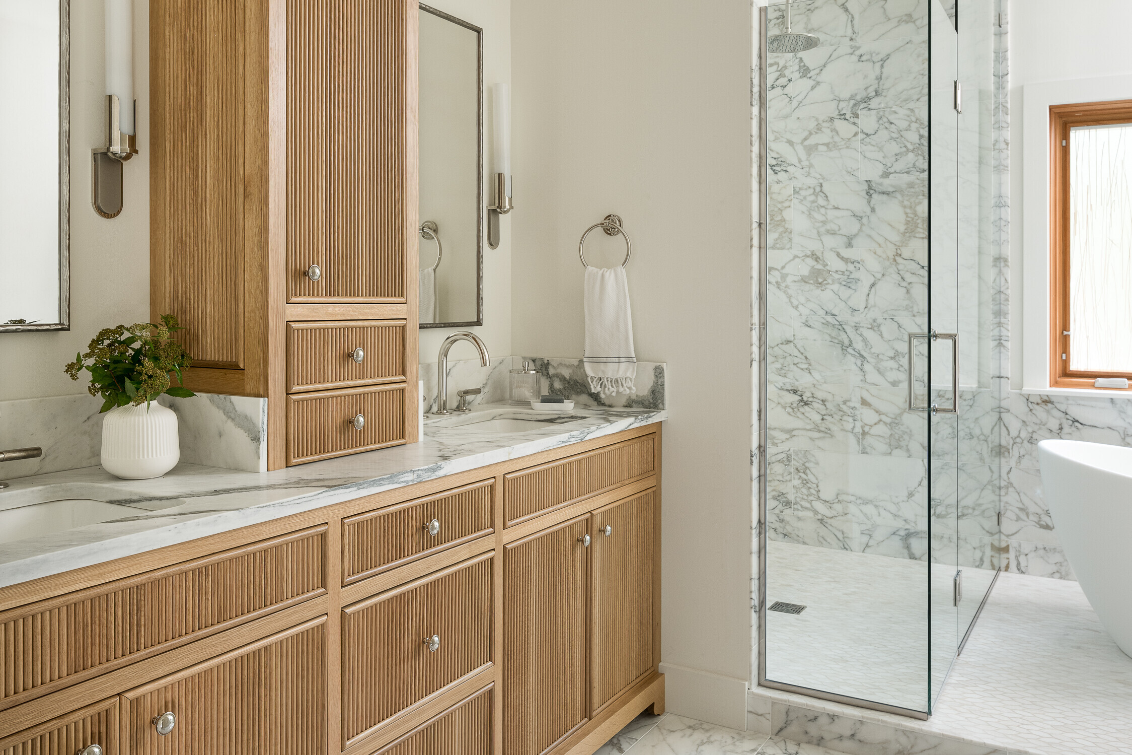 Bathroom featuring reeded inset cabinets, curbless shower and soaking tub 