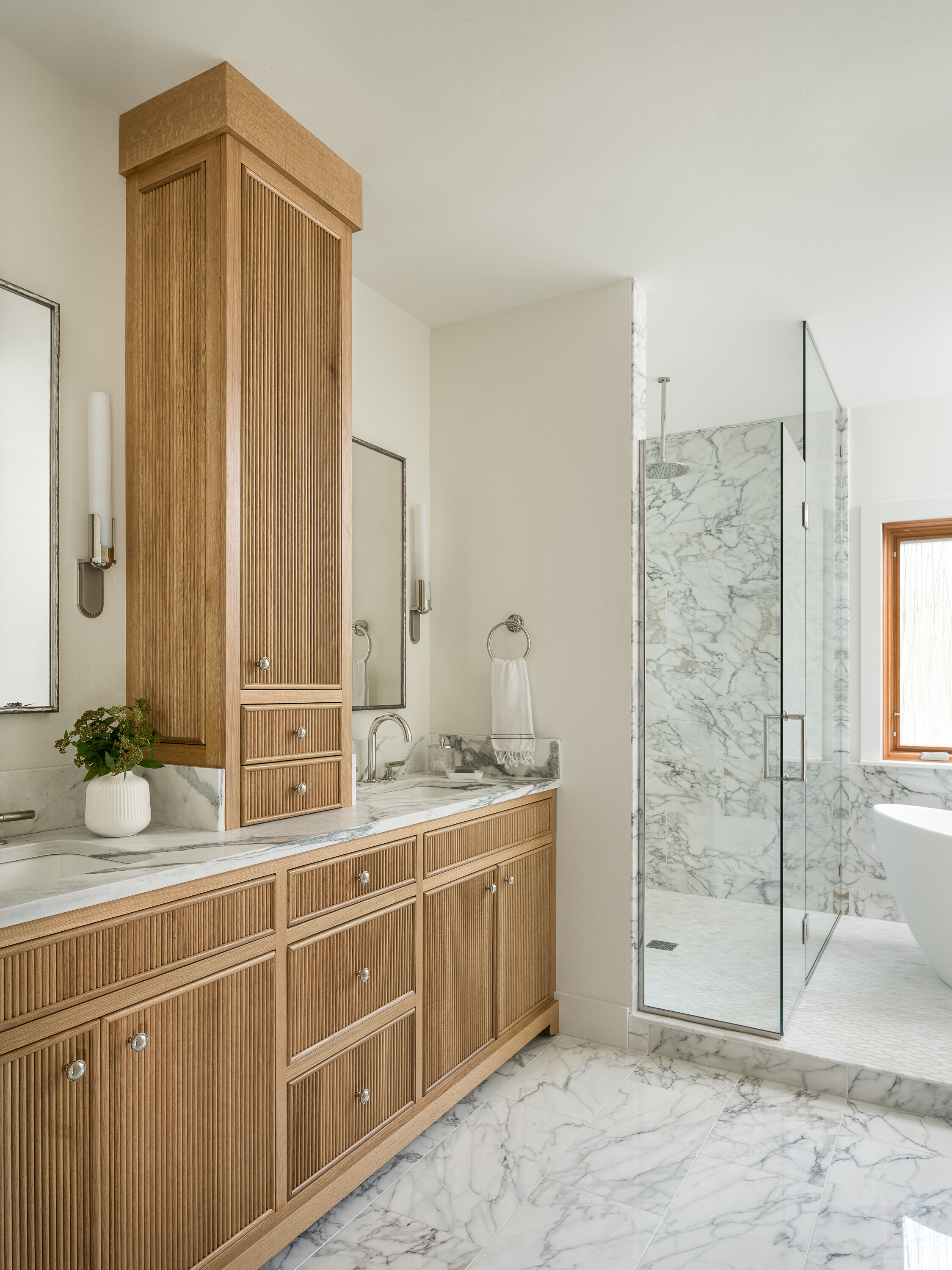 Bathroom featuring reeded inset cabinets, curbless shower and soaking tub 